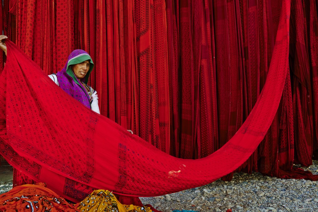 A worker at a sari factory in Rajasthan, India, drys the textile in the open air. From ancient India to international catwalks, the sari has a storied history. Photo: Getty Images