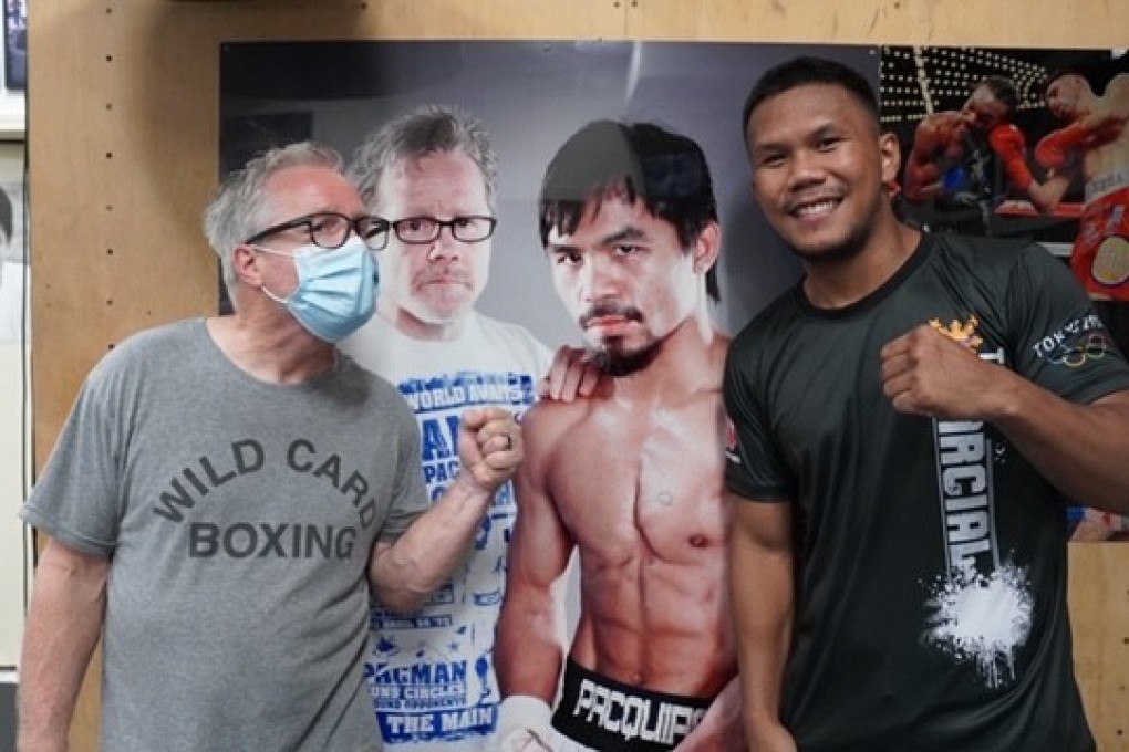 Freddie Roach and Eumir Marcial pose in front of a picture of Roach with Manny Pacquiao at the Wild Card Boxing Club in Hollywood, California. Photo: MP Promotions