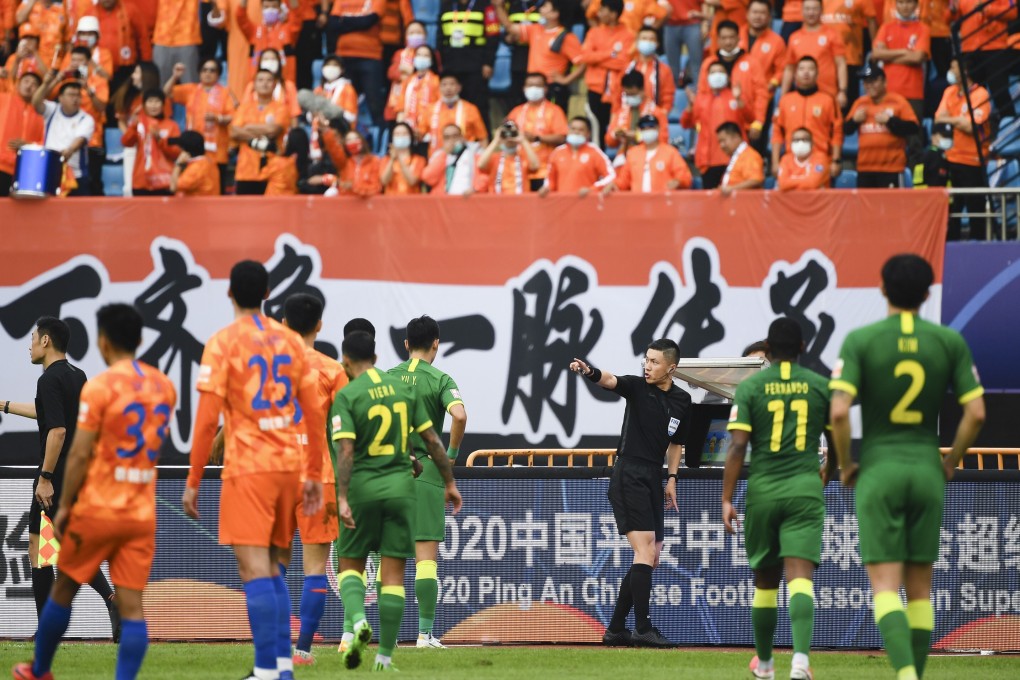 Referee Shen Yinhao gestures in front of Shandong Luneng’s fans in their Chinese Super League game against Beijing Guoan. Photo: Xinhua