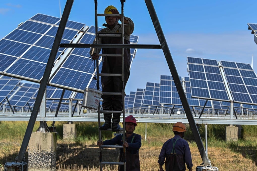 Workers work next to solar panels in an integrated power station in Yancheng city in Jiangsu province on October 14. Governments should consider focusing their support on public capital investment programmes, such as Infrastructure building, health facilities, education, and for the alleviation of climate change. Photo: AFP