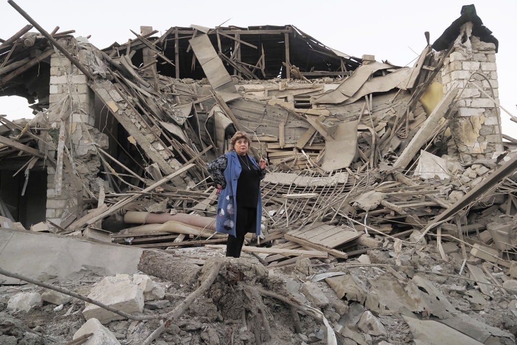 A woman stands near her destroyed house in Stepanakert, Nagorno-Karabakh. Photo: AP