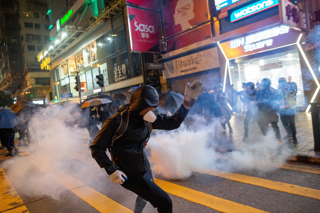 Protesters react after riot police fire tear gas during a rally in Tsim Sha Tsui, Hong Kong in December 2019. Photo: EPA-EFE