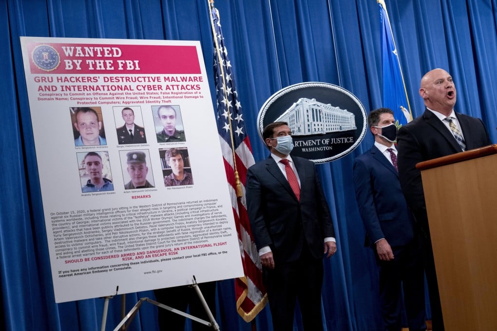 A poster showing six wanted Russian military intelligence officers is displayed as FBI Special Agent in Charge of the Pittsburgh field office Michael Christman speaks at a news conference at the Department of Justice on Monday. Photo: EPA-EFE
