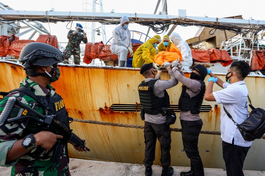 Indonesian police removing the body of an Indonesian crew member who was killed on board a fishing vessel off Batam Island in July. Photo: AFP