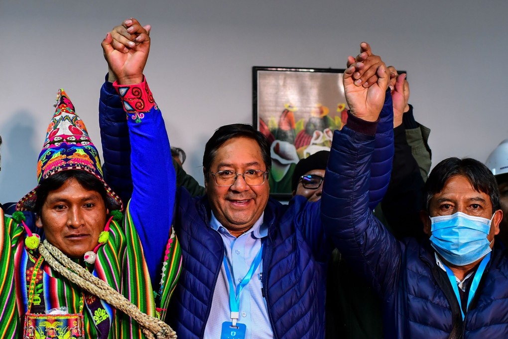 Luis Arce (centre) of the Movement for Socialism celebrates with running mate David Choquehuanca (right) in La Paz, Bolivia on Monday. Photo: AFP
