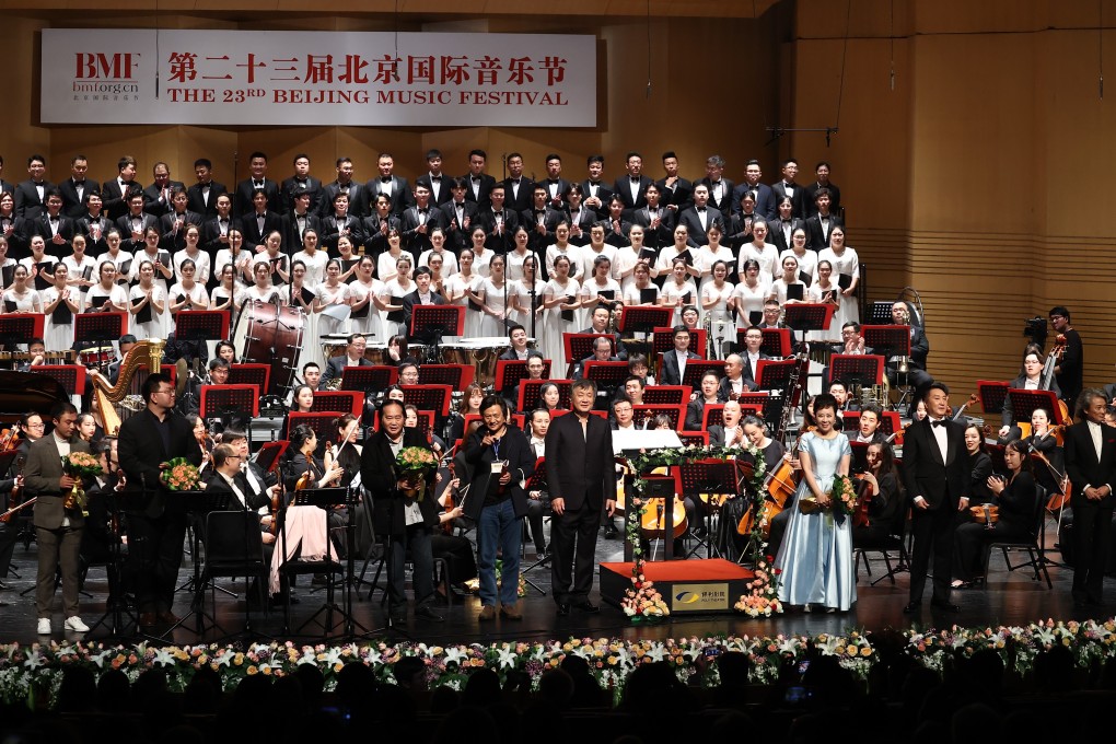 Orchestral players, choirs and singers receive the applause of the audience at Beijing Poly Theatre after a performance of Dedicated to 2020 – A Symphony for Soprano, Baritone, Chorus and Orchestra, the first large-scale orchestral work inspired by the Covid-19 outbreak.