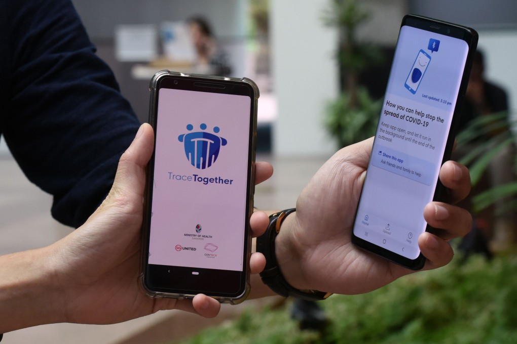 Government staff demonstrate TraceTogether, Singapore's contact-tracing smartphone app. Photo: AFP