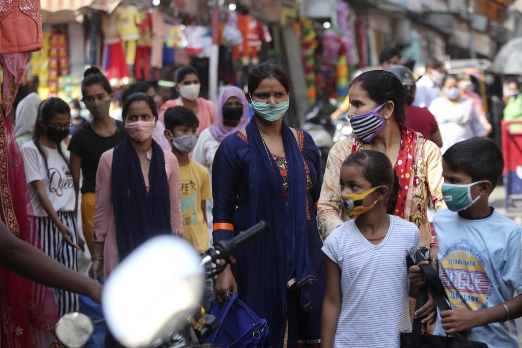 Indians wearing face masks as a precaution against the coronavirus walk in a market in Jammu. India is the world's second most affected country after the United States. Photo: AP