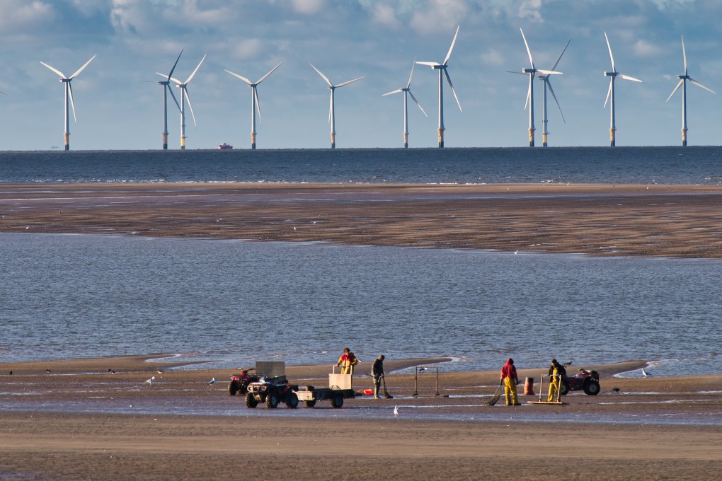 Cockle pickers off New Brighton in the Mersey Estuary. The wind turbines of Burbo Bank, some of the largest in the world, are in the background. File photo: Shutterstock
