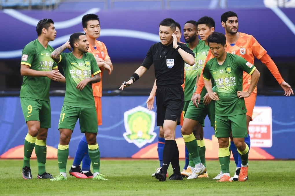 Referee Shen Yinhao (centre) reacts during the Chinese Super League match between Shandong Luneng and Beijing Guoan. Photo: Xinhua