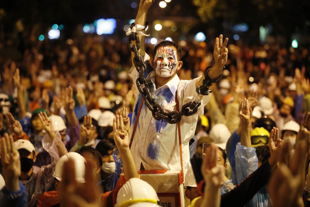 Pro-democracy protesters flash the three-finger salute during an anti-government protest in Bangkok on Wednesday night. Photo: EPA