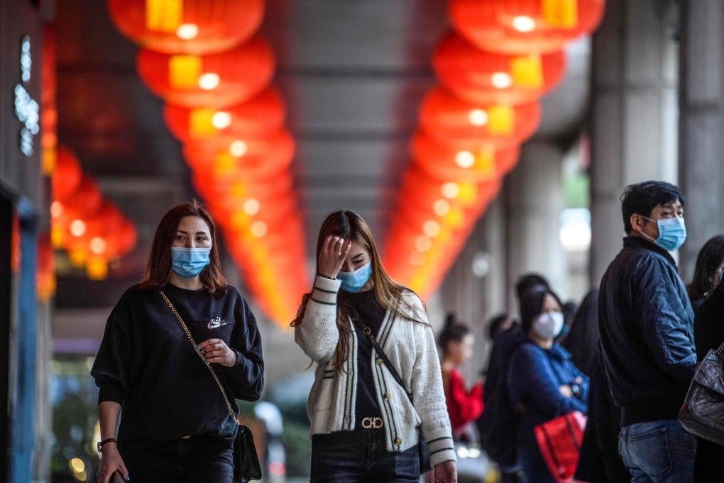 Pedestrians wear face masks as they walk outside the New Orient Landmark hotel in Macau on January 22, 2020. Photo AFP