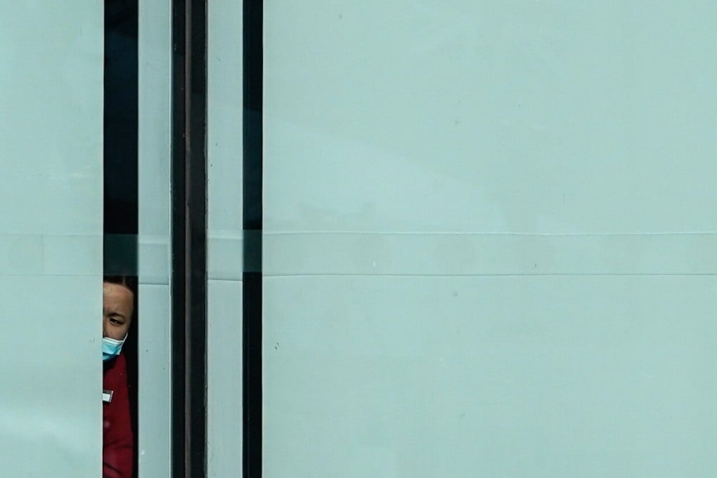 A woman peers out from a window at Cathay Pacific City at Hong Kong International Airport. Photo: Bloomberg