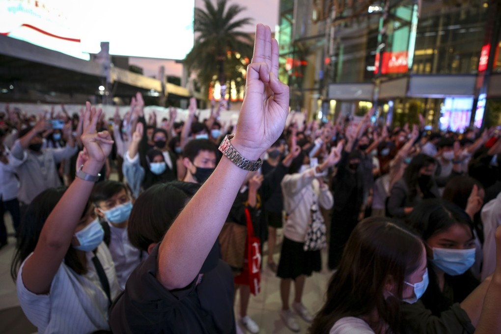 Pro-democracy protesters flash the three-finger salute outside Siam BTS station in Bangkok. Photo: EPA