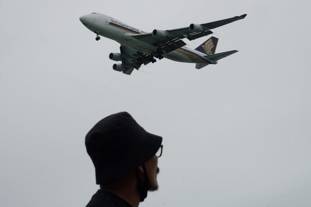 A man looks on as a Singapore Airlines plane approaches for landing at Changi International Airport in Singapore. Photo: AFP