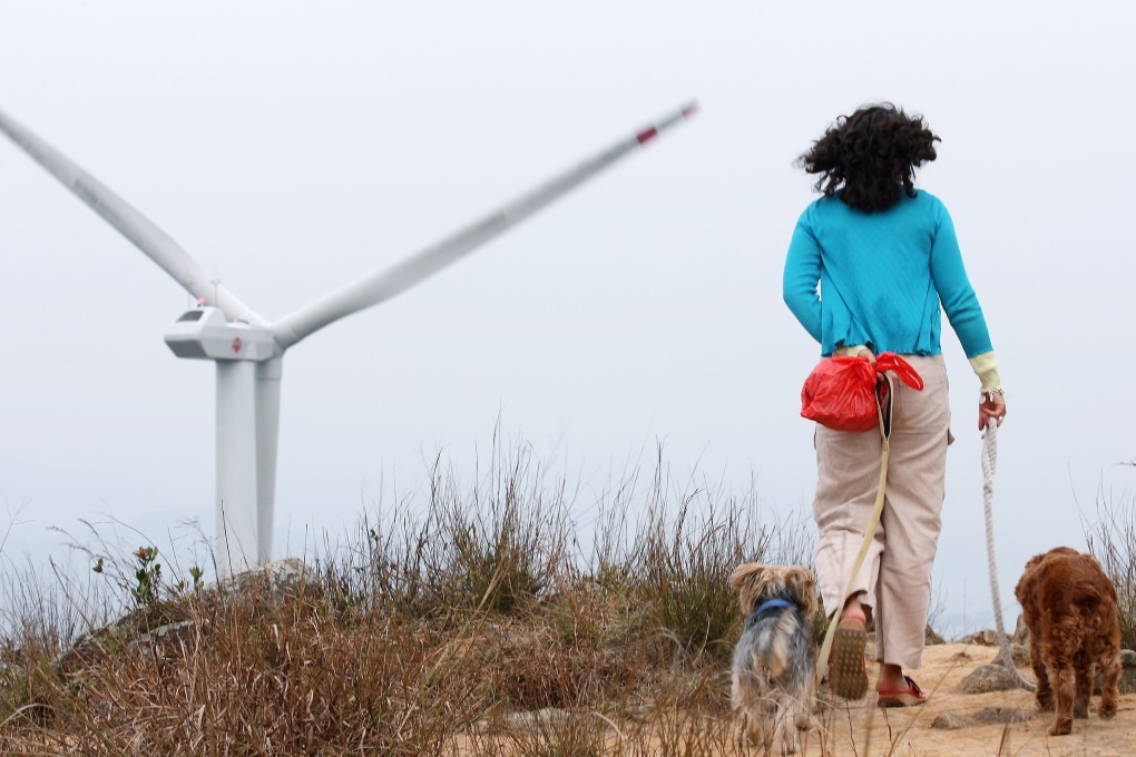 A woman and her dogs pass Hong Kong’s first wind power station on Lamma Island in February 2006. The HK2050 is Now plan for getting Hong Kong to net zero carbon emissions by 2050 says developing local renewable energy sources can help abate as much as 27 metric tons of carbon dioxide emissions. Photo: Martin Chan
