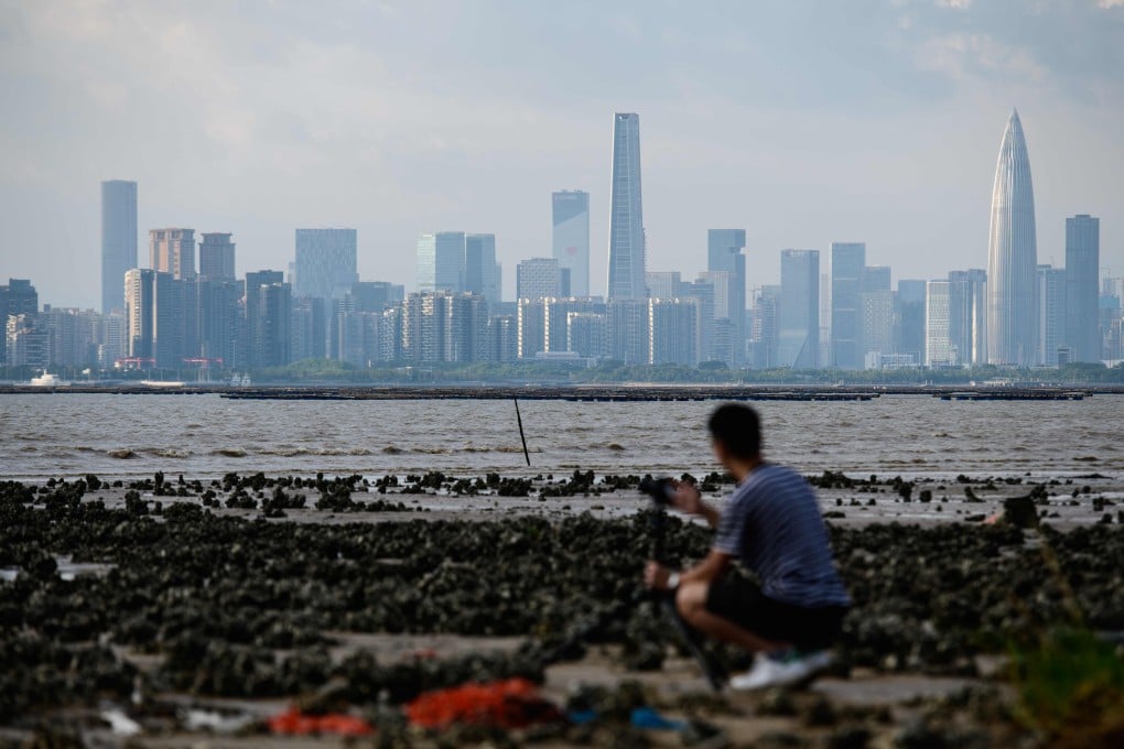 A man in Hong Kong sets up a camera as he looks towards the mainland city of Shenzhen, part of the Greater Bay Area plan. Photo: AFP