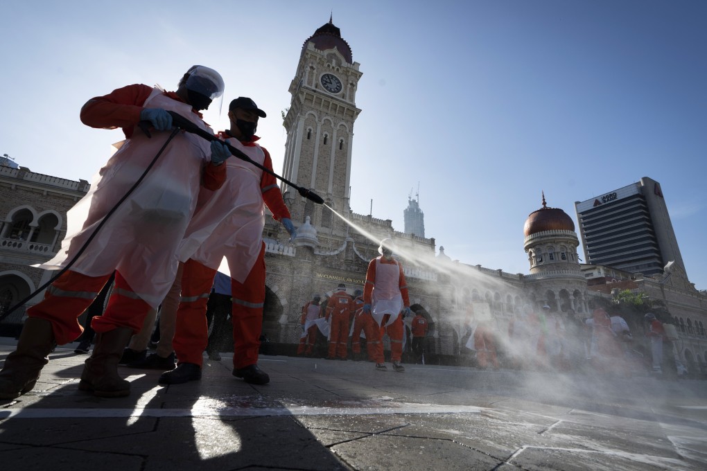 Workers disinfect the Merdeka Square in Kuala Lumpur, Malaysia. Photo: AP
