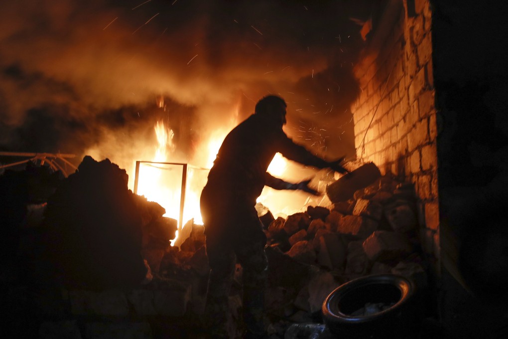 People try to remove car tyres from a car shop on fire after shelling by Azerbaijan's artillery in Stepanakert, the separatist region of Nagorno-Karabakh, on Friday. Photo: AP