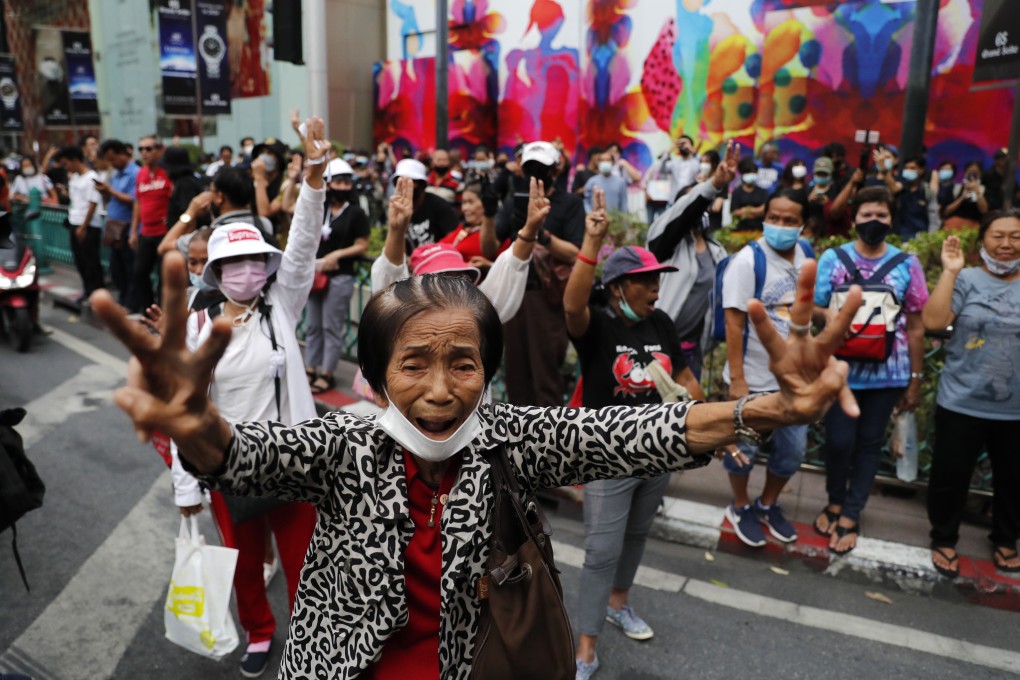 Pro-democracy protesters flashing three-fingered salutes near a main shopping district in Bangkok on Sunday. Photo: AP