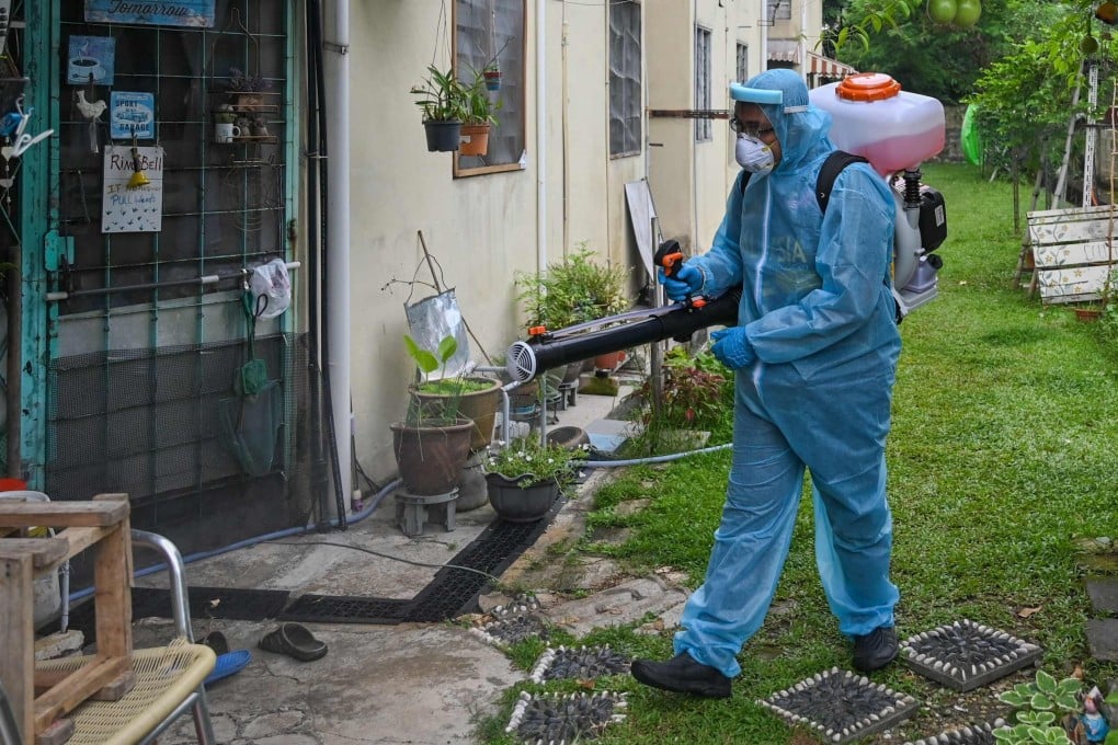 A worker sprays disinfectant in the backyard of a building in Kuala Lumpur. Photo: AFP