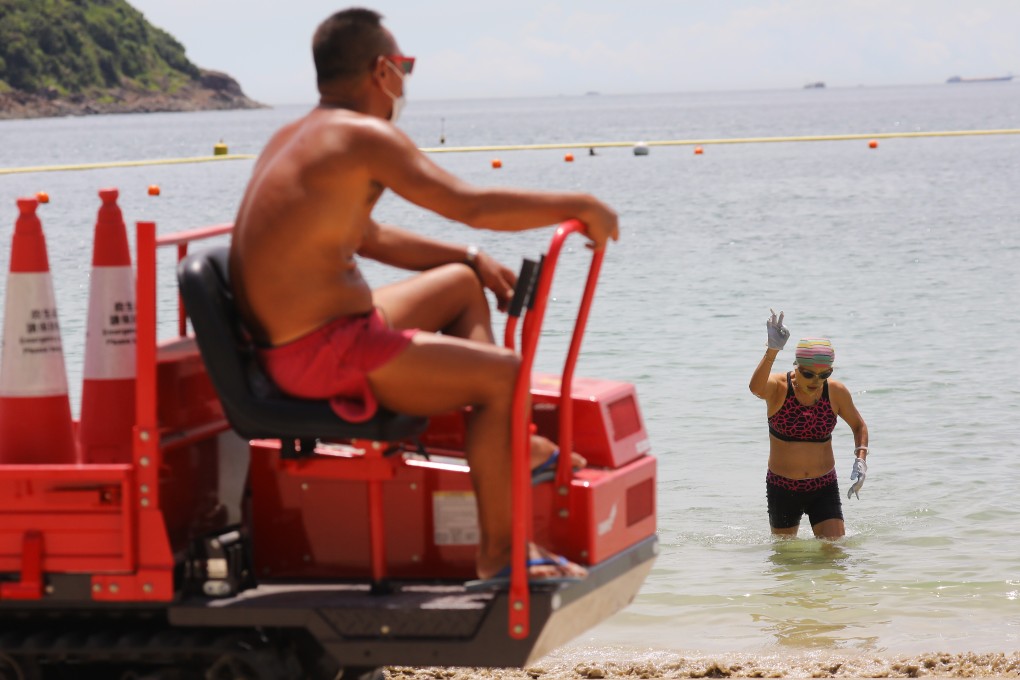A swimmer comes out of the water as a lifeguard looks on at a beach in Clear Water Bay on July 25. Hong Kong has closed beaches as part of its coronavirus containment measures. Photo: Dickson Lee