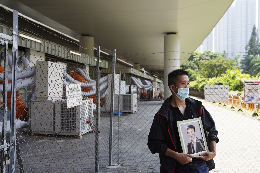 Volunteer Man Kong holds a picture of Le Van Muoi in front of the area in Sham Shui Po where he used to sleep. Photo: Sam Tsang