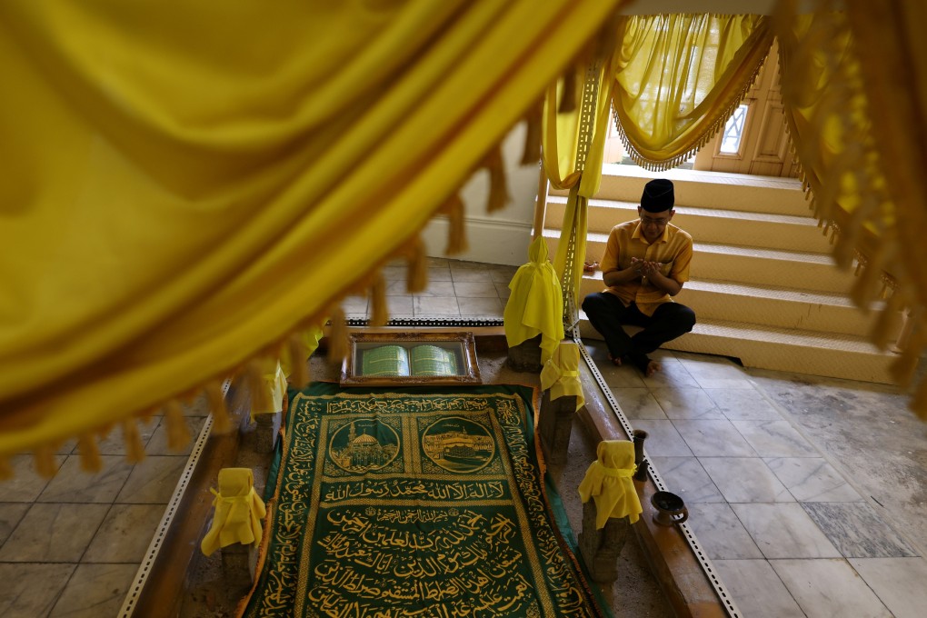 Tengku Shawal, a royal descendant, says a prayer next to the tombstone of his great-great-grandfather, Tengku Alam. Photo: Reuters