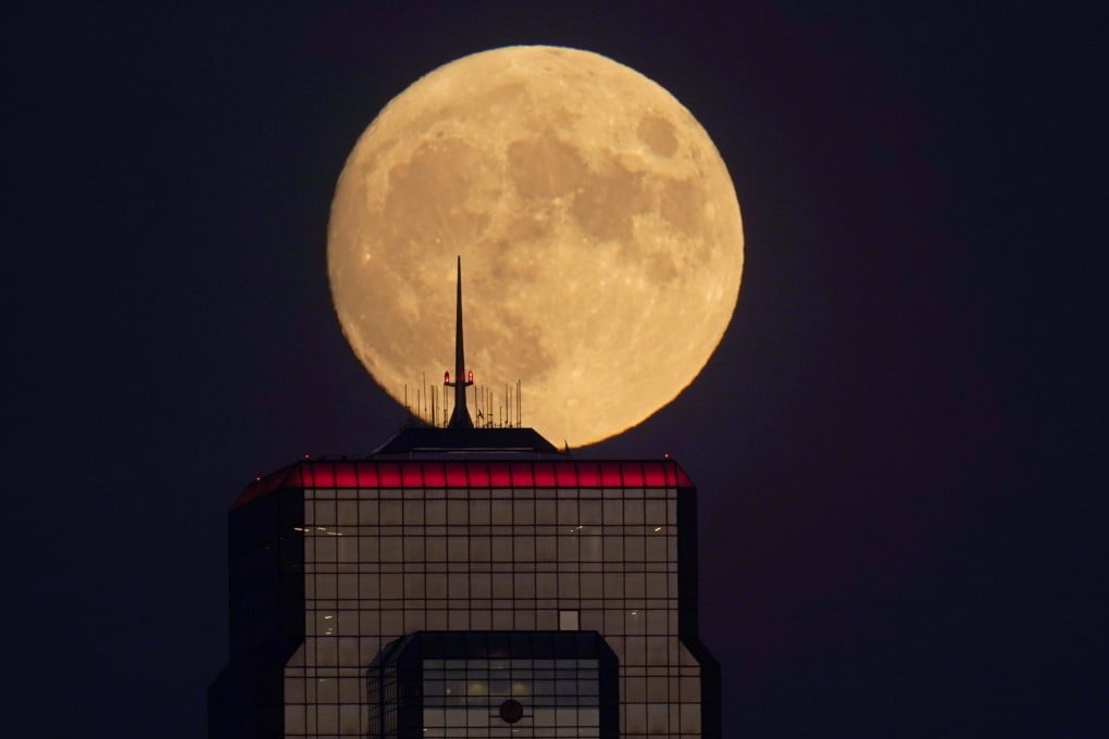 A nearly full moon rises, with an office building in the foreground, in downtown Kansas City, Missouri, in September. Photo: AP