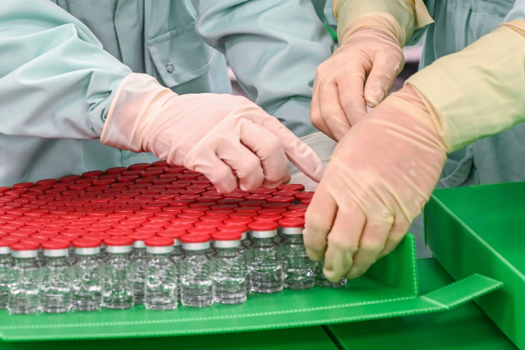 Laboratory technicians handle capped vials for the large-scale production and supply of Oxford University’s Covid-19 vaccine candidate, AZD1222. Many companies and scientists are racing to develop a vaccine but the manufacturing and distribution phases will bring their own issues. Photo: AFP