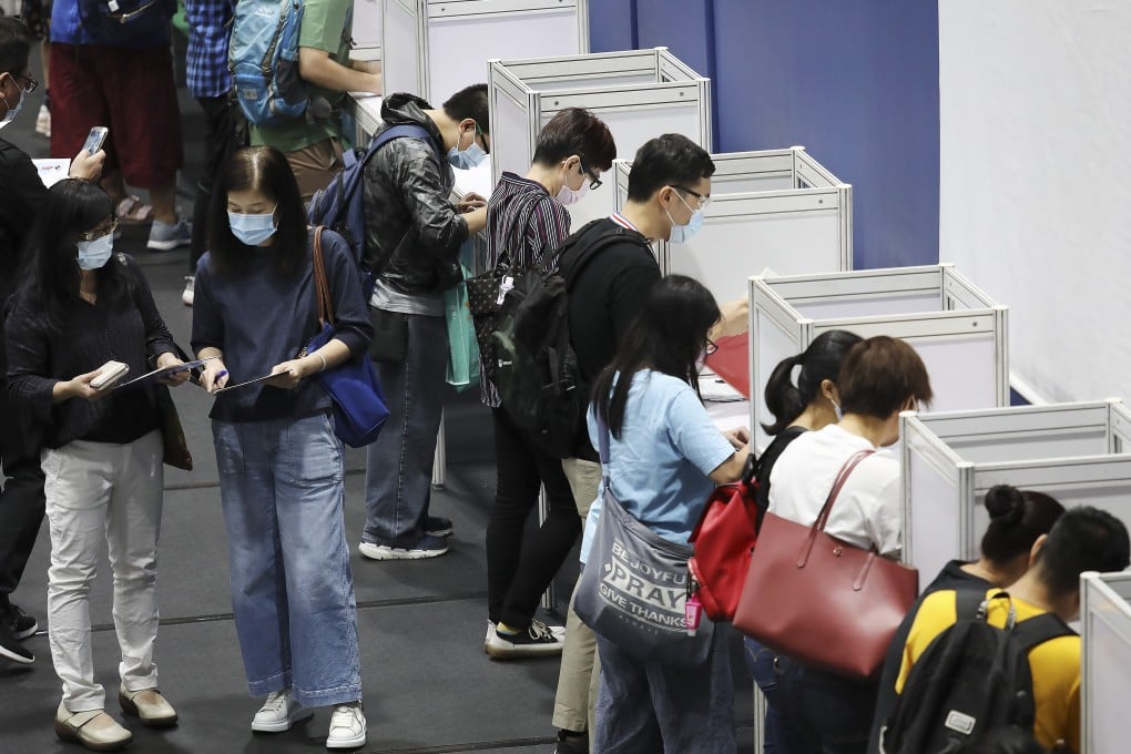 Jobseekers fill out application forms at a fair organised by the Labour Department at Southorn Stadium in Wan Chai on Wednesday. Photo: Nora Tam