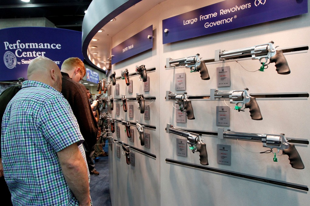 Gun enthusiasts look over Smith & Wesson guns at a National Rifle Association meeting in Louisville, Kentucky. Photo: Reuters