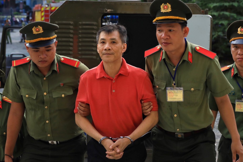 US citizen Michael Nguyen is escorted by policemen before his trial in Ho Chi Minh City in June 2019. Photo: Reuters
