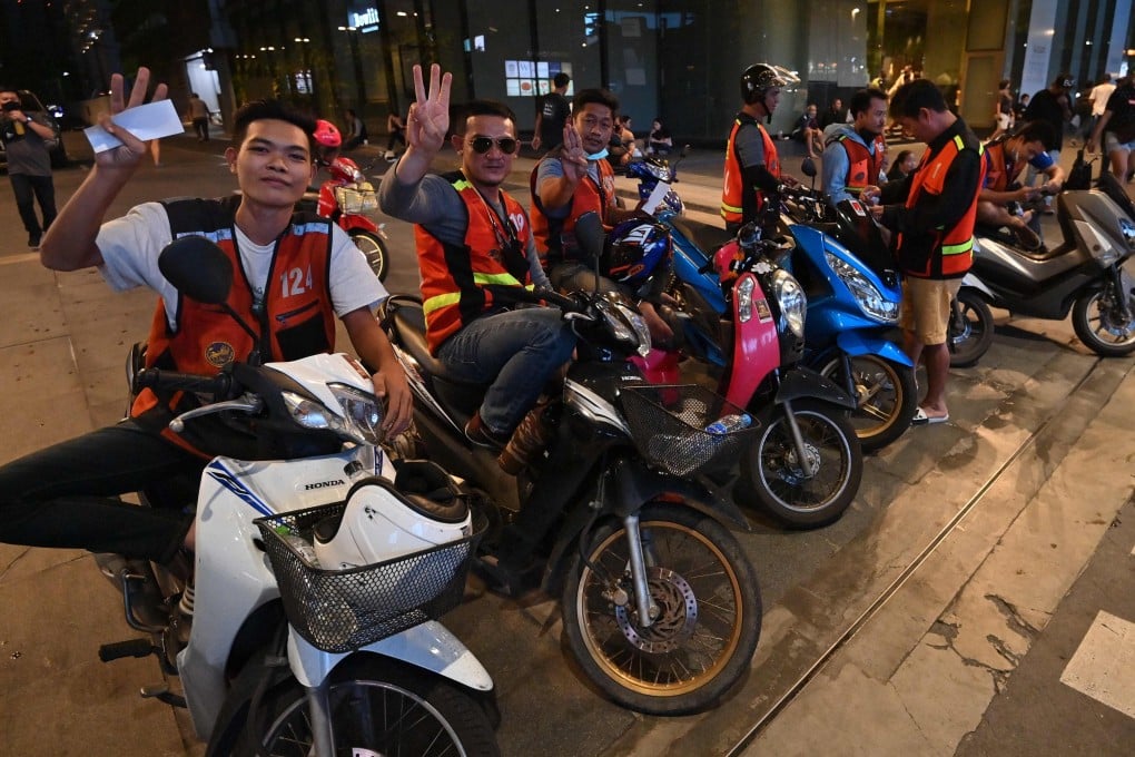 Taxi riders hold up the three-finger salute in Bangkok. Photo: AFP