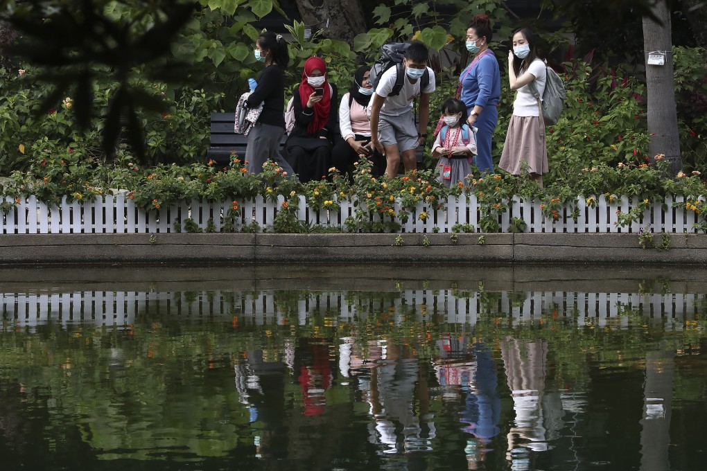 Visitors keep their masks on in Hong Kong Park in Admiralty. Hong Kong will allow six people to sit together in restaurants, but still bans public gatherings of more than four. Photo: Jonathan Wong