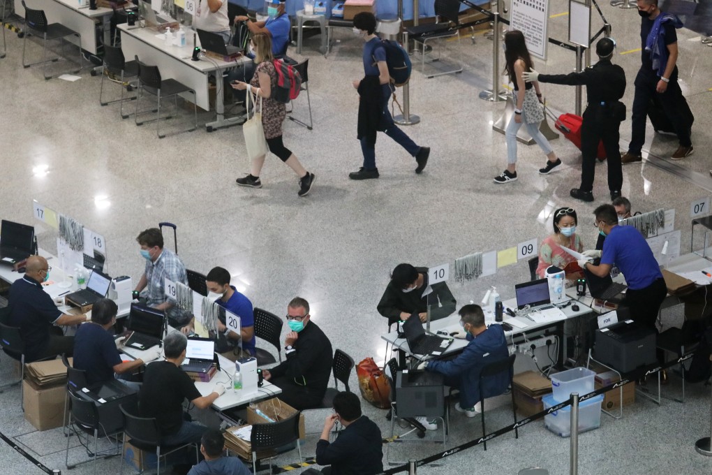 Travellers receive their quarantine wristbands upon arrival at the Hong Kong International Airport on July 21. Photo: Nora Tam