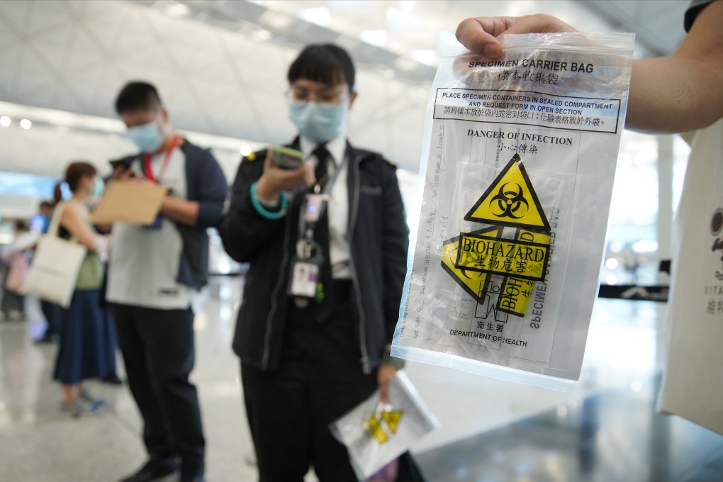 An airport staff holding a specimen sample for Covid-19 tests as part of the Department of Health’s Enhanced Laboratory Surveillance Programme at the Hong Kong International Airport in Chek Lap Kok on 22 July 2020. Photo: Winson Wong
