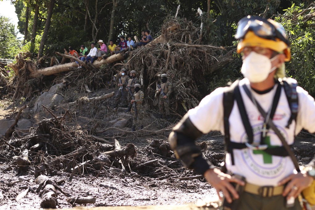 A rescuer stands near the trunk of a tree that fell during a deadly landslide in Nejapa, El Salvador on Friday. Photo: AP