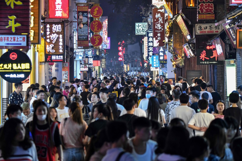 Crowds walk though a street flanked by small shops in the city of Changsha, Hunan province. The world is likely to experience a gradual, albeit choppy, economic recovery. Photo: AFP