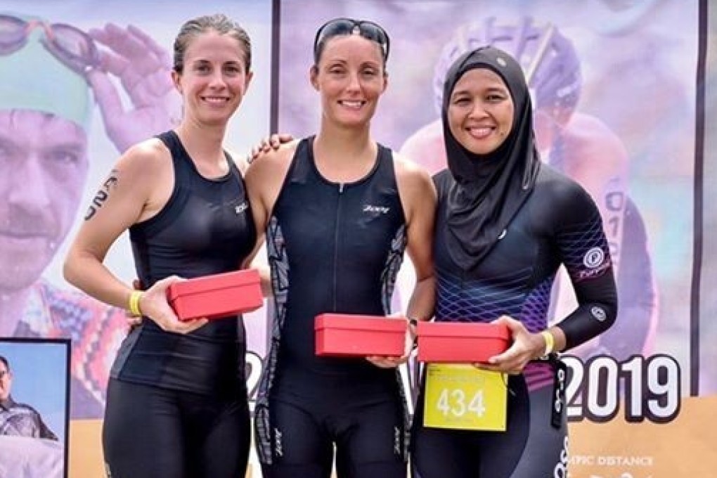 Nur Syahariah Jusoh (right) with fellow athletes at the 2019 Ironman Triathlon race wearing a sports hijab.
