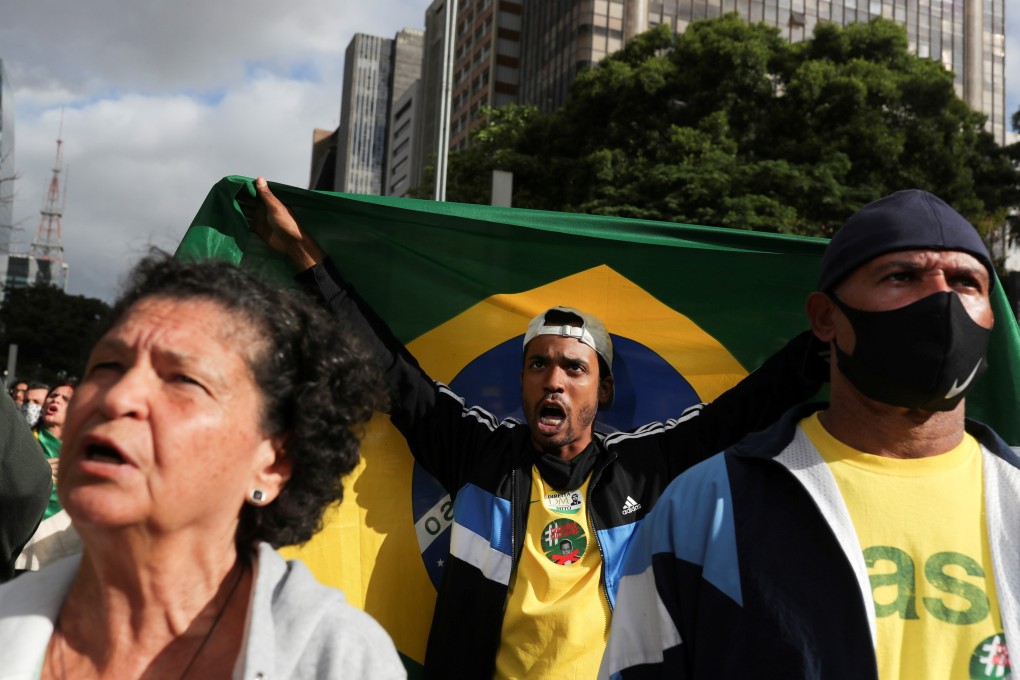 A man holds a Brazilian flag as demonstrators protest against Sao Paulo state governor Joao Doria and China's Sinovac potential coronavirus vaccine in Sao Paulo on Sunday. Photo: Reuters
