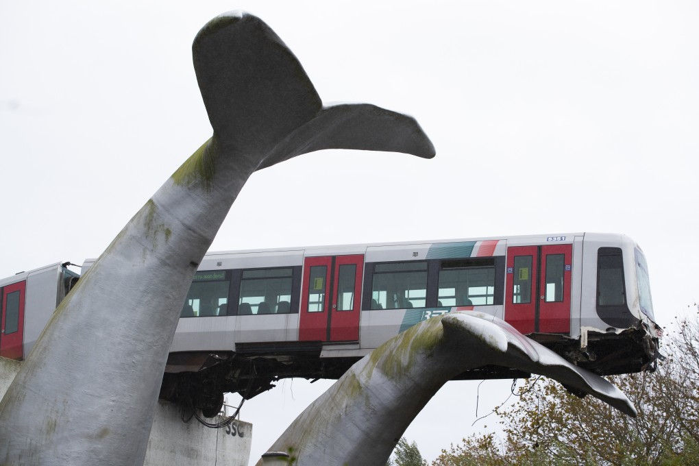A whale tail sculpture caught the front carriage of a metro train as it rammed through the end of an elevated section of rails in the Netherlands. Photo: AP