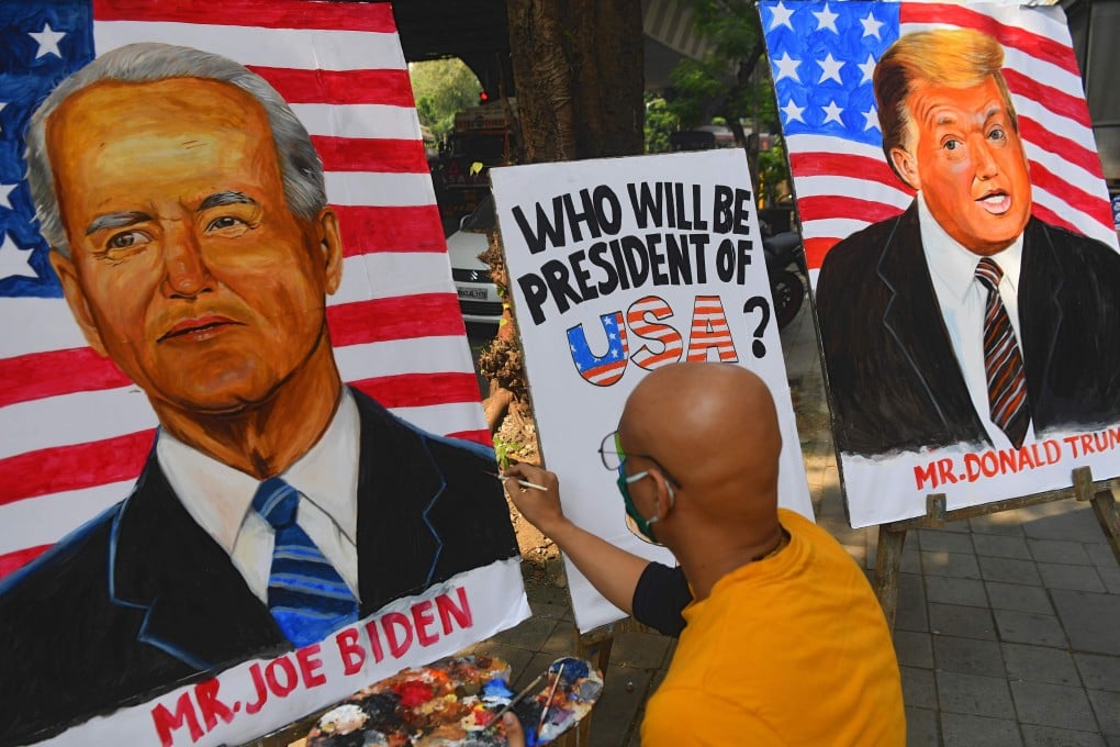 An artist paints an image of Joe Biden next to a painting of US President Donald Trump in Mumbai, India. Photo: AFP
