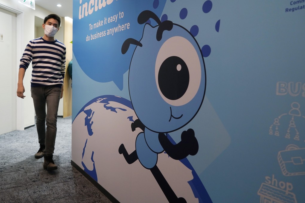 An employee walks past a graphic of the Ant Group’s mascot at their office in Hong Kong. The world's largest fintech company is raising more than US$39 billion in a massive dual public offering. Photo: AP Photo