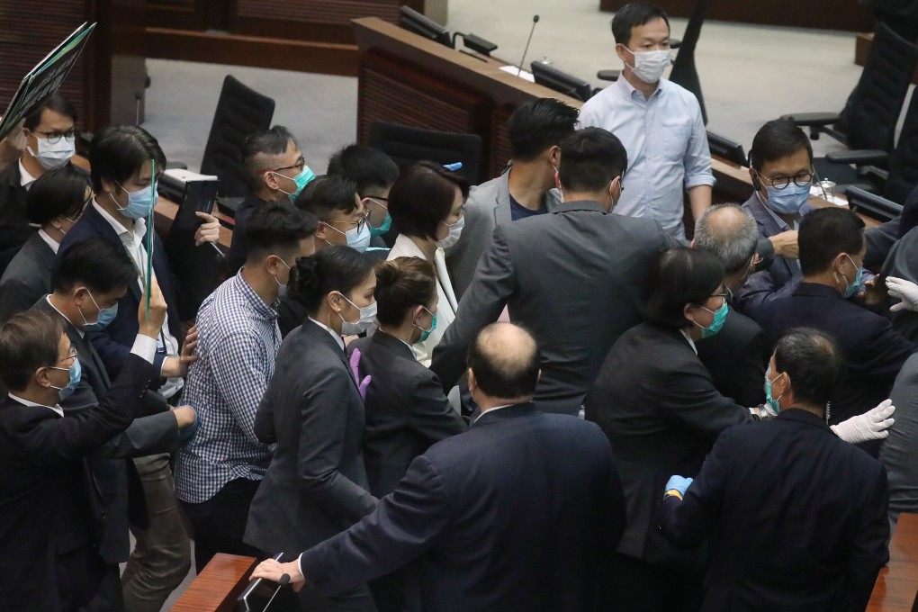 Chairwoman of the House Committee DAB Lawmaker Starry Lee Wai-king (centre in white) leaves the chamber surrounded by security guards, during a Legislative Council meeting. Photo: Dickson Lee