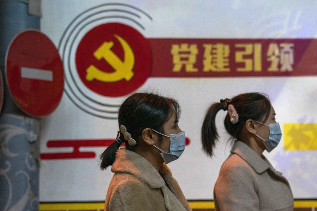 Pedestrians pass by the Communist Party logo and the slogan “Party building leadership” in Beijing on October 29. China says it will promote technological self-reliance in its latest five-year plan while still opening further to trade. Photo: AP