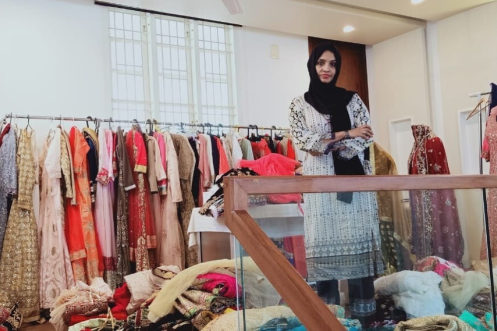 Sabitha pictured with some of the dresses and saris on offer in Rainbow Women’s Outfits. Photo: Amrit Dhillon