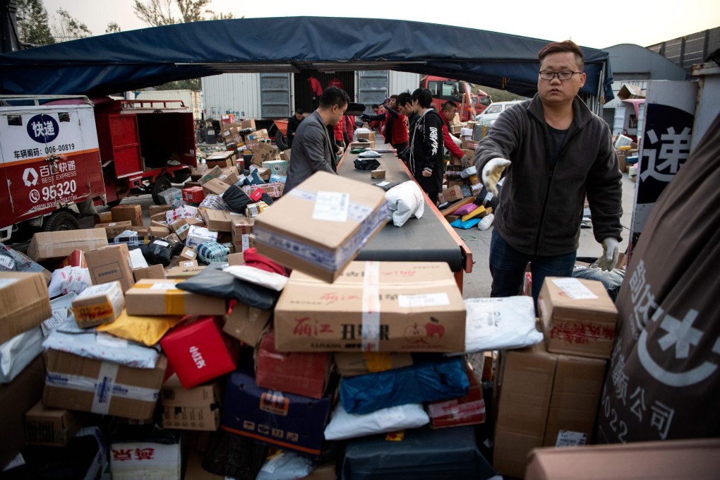Workers sort out packages to be delivered to customers a day after Singles’ Day at a delivery company warehouse in Beijing on November 12, 2019. Photo: AFP