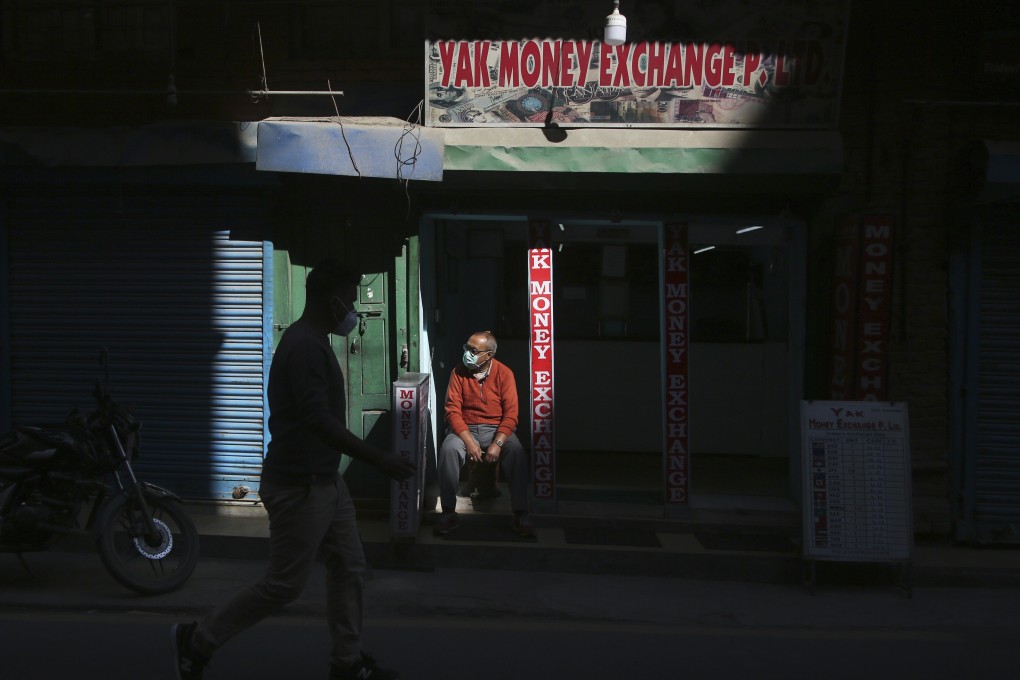 Business is hard to come by for a money changer in Kathmandu, Nepal. Photo: Niranjan Shrestha/AP