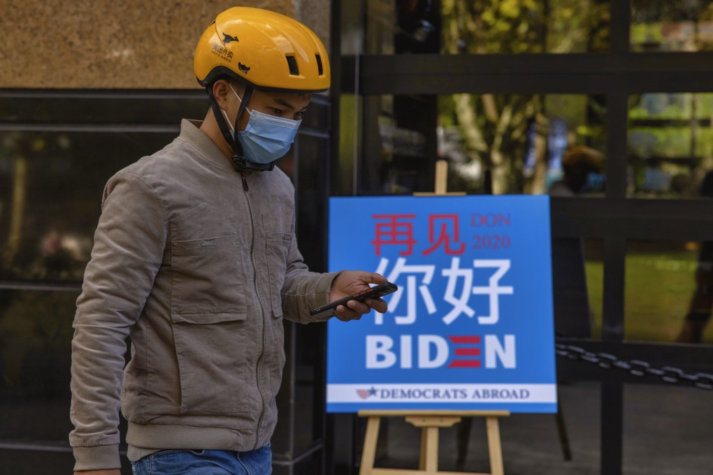 A delivery man passes a board for a US election watch party hosted by Democrats Abroad in Shanghai, China. Photo: EPA